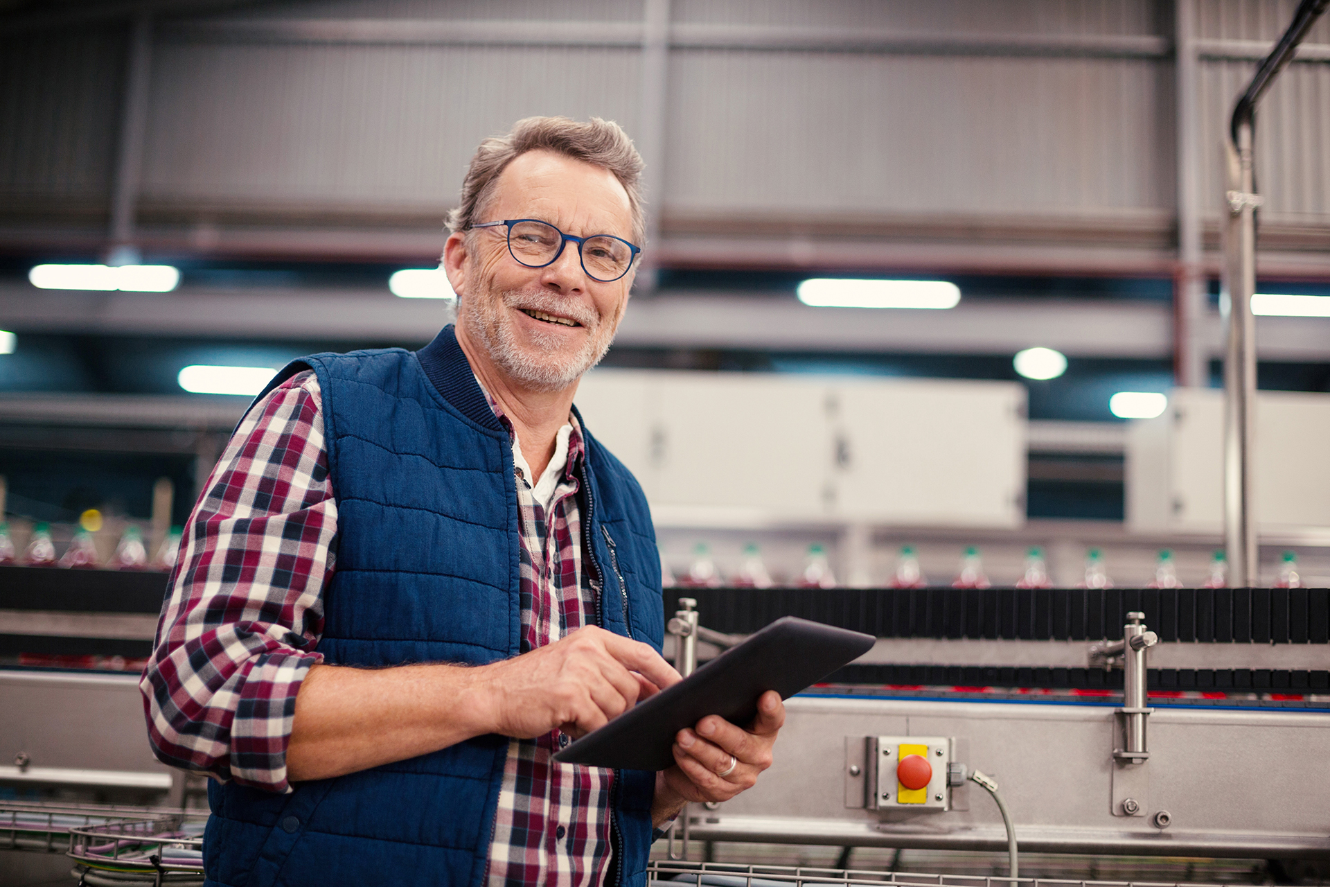 Smiling factory worker using digital tablet in the factory MS